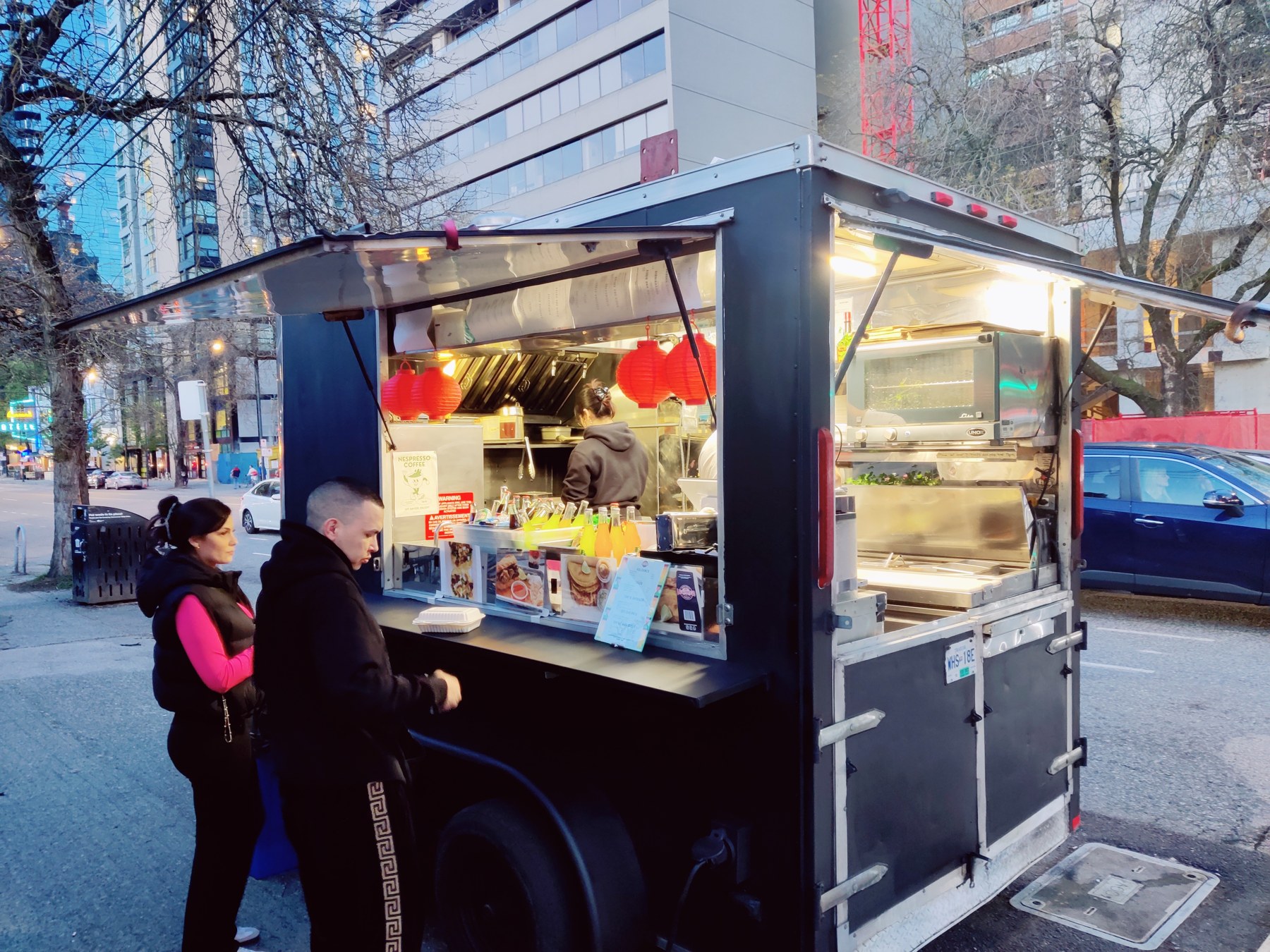 Full, unobstructed photograph of the actual taco trailer, showing the side serving window, rear hatch, kitchen equipment and body during downtown service